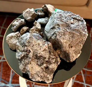 The blue-grey ambergris lot seen from overhead on a round black table