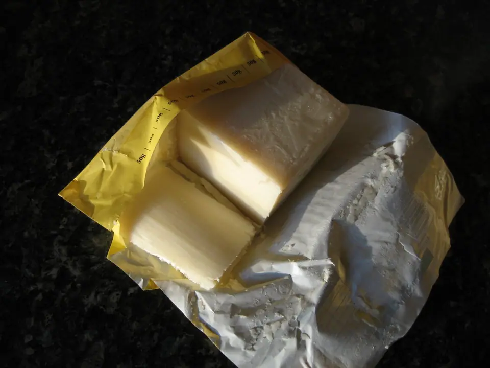 An unwrapped block of solid, pale palm oil